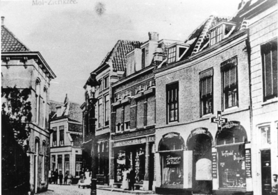 ZS-0885 Zierikzee. Mol. V.l.n.r: de tabaks- en sigarenwinkel van Arie Arnold, de kledingzaak van E. Kohschulte, het ...