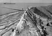 A-1952 Den Osse. Zeedijk. Aanleg noodleidingen van eternitbuizen, gezien vanaf de kruin van de dijk. Herstel ...