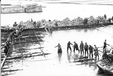 O-1426 Schelphoek (?) Afzinken zinkstuk. Het belasten van een zinkstuk met stenen: deze worden hand over hand doorgegeven.