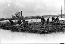 O-1750 Schelphoek. Een stoombaggermolen met onderlossers. Op de voorgrond het vervaardigen van een rijshout en zinkstuk.