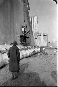 BE-0233 Neeltje Jans / Oosterscheldekering. Onbekende dame bekijkt hoe het laatste beton in de tijdelijke doorgang van ...