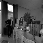 BE-0296 Zierikzee Bijeenkomst waarbij kunstwerken worden aangeboden.. Links staande kunstenaar Gerrit van de Ven, ...