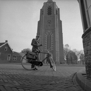 BE-0964 Nieuwerkerk Kerkring. Toren bij de Nederlands Hervormde kerk, gezien vanuit de Weststraat. Naast zijn fiets ...