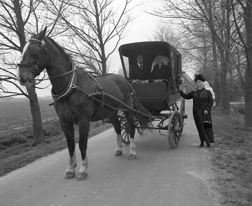 BE-1898 Burgh-Haamstede. Wim de Vrieze met vriendin gehuld in Schouwse streekdracht. Zij rijden in een een Schouws ...