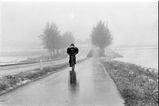 JVH-1617 Zierikzee. Lange Blokweg. Sneeuw in april. Fietser fietst in wit landschap in de richting van de overgang over ...