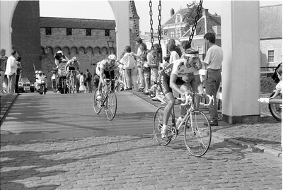 JVH-1976 Zierikzee. Oude Haven. Zuidhavenpoort. Deelnemers aan de wielerronde van Midden-Zeeland rijden over de ...