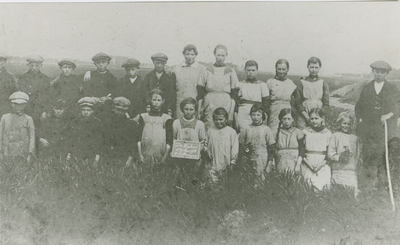 1301 Een groep kinderen op een akker bij Axel. Op het bordje staat de tekst De Wieken 27 mei 1918 P. van Bendegem 