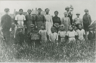 1302 Een groep kinderen op een akker bij Axel. Op het bordje staat de tekst De Wieken 28 mei 1918 P. van Bendegem 