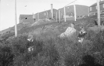 21.1-42 Een vrouw met twee jongetjes, met huizen op de achtergrond