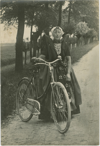 KLD-73 Zeeland, Zeeuwsch-Vlaanderen Axelscheboerin. Een vrouw in Axelse dracht met een fiets