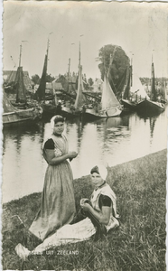 KLD-P-156 Groeten uit Zeeland. Twee vrouwen in Arnemuidse dracht bij de haven van Arnemuiden