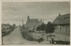 LEW-P-20 Groeten uit Lewedorp. De Burgemeester Lewestraat met de Rooms-katholieke kerk te Lewedorp