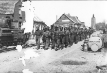 170 NFR Geallieerde militairen lopen in de Zuidstraat te Westkapelle met schoppen.