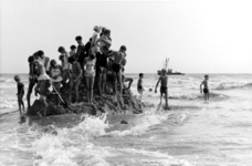 199 NFR Kinderen op een berg zand omringd door de zee bij het strand te Westkapelle.