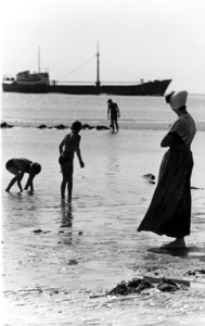 210 NFR Strandplezier op het strand bij Westkapelle met een moeder in dracht, spelende kinderen en op de achtergrond ...