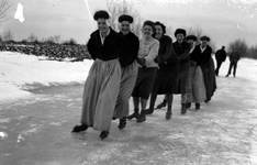 267 NFR Vrouwen in dracht schaatsen op de bocht bij Westkapelle.