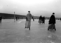 268 NFR Vrouwen in dracht schaatsen op de bocht bij Westkapelle.