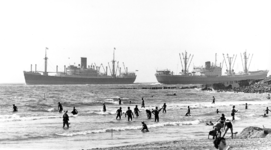 434 NFR Strandplezier op het strand bij Westkapelle met op de achtergrond twee voorbijvarende schepen.
