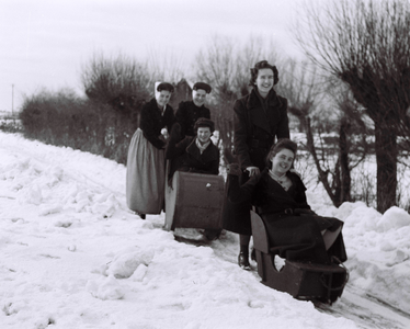 553 NFR Enkele vrouwen met sleestoelen in een winterlandschap bij Westkapelle.