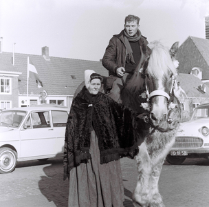 571 NFR Man op een paard, met daarnaast een oudere vrouw in dracht tijdens de intocht van burgemeester Bulder te Westkapelle.