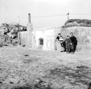 94 PH De familie W. Huibregtse poseert bij een bunkerwoning te Westkapelle.