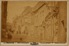 4973 Het Groenewoud gezien in de richting van de Walstraat. Achter de man rechts is een poortje daterend uit 1614. Op ...