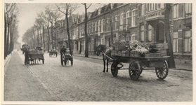 11176 Straatbeeld Badhuisstraat. Midden op de foto een melkboer met handkar, op de voorgrond een groenteboer met paard ...