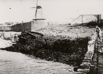 11711 Tweede Wereldoorlog. De Oranjedijk met molen en daarnaast liggend terrein na de landing der geallieerden en ...