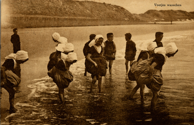 13249 'Voetjes wasschen'. Een groep jongens en meisjes in klederdracht zijn aan het pootjebaden in zee
