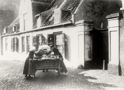 15423 Melkverkoper in de Koestraat. De huisjes behoren tot het oude Gasthuis. Voor andere foto's van het Gasthuis, zie: ...