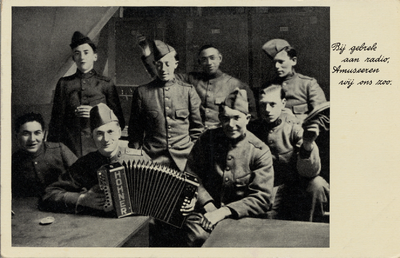 16829 'Bij gebrek aan radio. Amuseeren wij ons zoo' Groep soldaten met een accordion