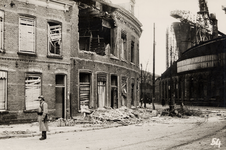 21138 Tweede Wereldoorlog. Verwoeste panden op de hoek Badhuisstraat, Aagje Dekenstraat. Rechts de smederij van de Kon. ...