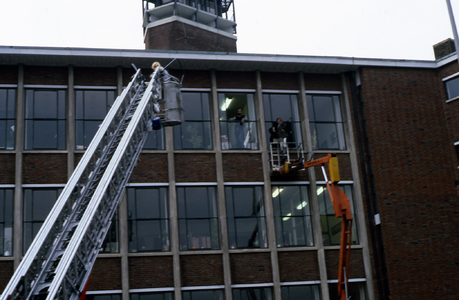 21822 De werkbak van de hoogwerker van de brandweer wordt naar haar juiste positie gedirigeerd. Deze hoogwerker was te ...