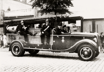 25596 De brandweerauto M2 Ford V8 (later M5) in de Van Dishoeckstraat in Vlissingen. Van links naar rechts Bart ...