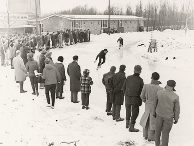 28113 Schaatswedstrijden op de sintelbaan aan de Baskensburgweg tijdens de strenge winter van 1963. Op de foto ziet men ...