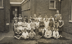 35772 Klas 3 en 4 van de openbare school A aan de Coosje Buskenstraat, de Duinpoortschool. met rechts onderwijzer J. Karels