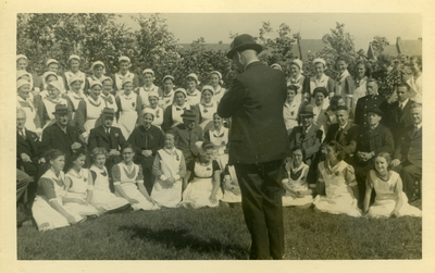 47221 In de tuin van ziekenhuis Bethesda. dr. Wolters neemt de foto. Op de tweede rij van onder zitten: dr. Smit (l.), ...