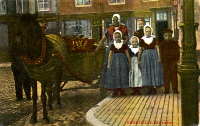 56959 Groete uit Zeeland. Groep personen met paard en wagen op de Nieuwendijk te Vlissingen, met op de achtergrond ...