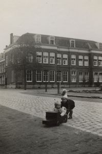 57600 Spelende kinderen in de Van Dishoeckstraat met op de achtergrond een gedeelte van het Sint Joseph ziekenhuis aan ...