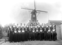57976 Groepsfoto van het Westkappels dameskoor onder leiding van dirigent Piet de Rooij. Op de achtergrond de ...