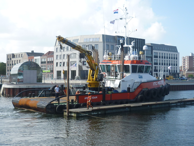 58090 De sleepboot ITC Meltemi tijdens werkzaamheden in Dokhaven. Op de achtergrond de bebouwing (o.a. ...