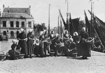 12104 'Vlissingen. Visschersvrouwen'. Op de Ballastkade met op de achtergrond het politiebureau. Van l. naar r.: ...