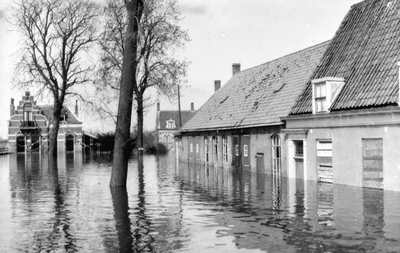 32 Tweede Wereldoorlog. Oranjeplein in Oost-Souburg na de inundatie in oktober 1944, met rechts de smederij van ...
