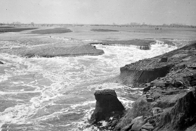 8 Tweede Wereldoorlog. Na de inundatie van Walcheren in oktober 1944, één der dijkgaten. Links de Dom en de molen van Veere