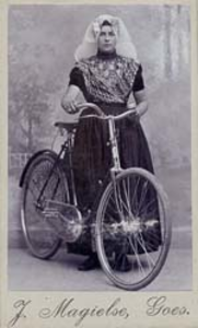 1114 Klasina Smits (*1888) e.v. Adriaan de Winter, in klederdracht met een fiets