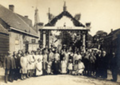 307 Groepsfoto van inwoners van Groede bij een ereboog ter gelegenheid van het muziekfeest in 1930. Cornelis Brakman, ...