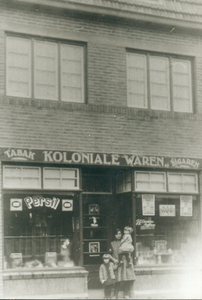 407_0185 Vrouw met twee meisjes in deuropening van winkelpand in de Sint Petrusstraat te Overhoven