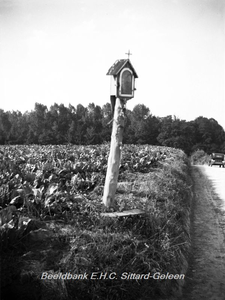 ehc_gp_132 Kapelletje op een houten paal langs een veldweg met passerende auto in het Limburgse landschap