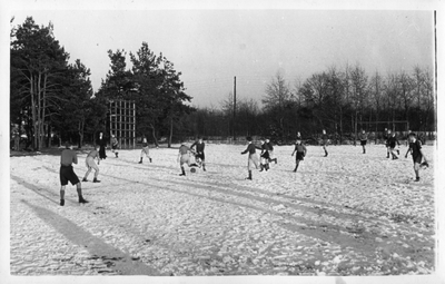 267104 Leerlingen voetballen in de sneeuw op een sportveld bij het internaat Maria Mediatrix te Azelo