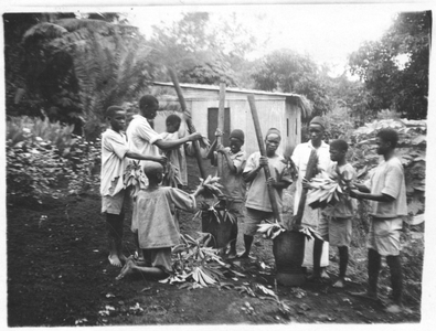 161283 Leerlingen stampen maniokbladeren om ze tot fijne spinazie te koken te Morogoro, Bagamoyo (Tanzania)